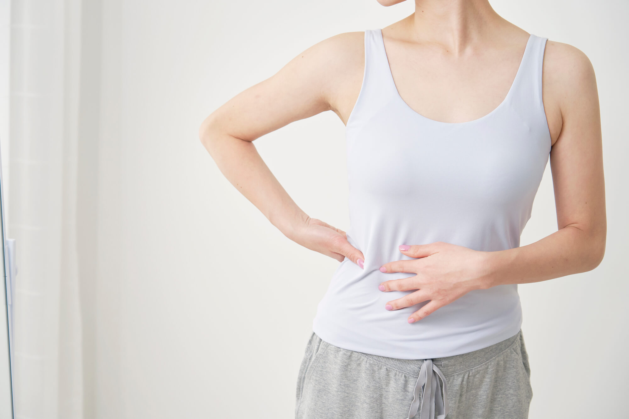 おなかに手を当てる女性