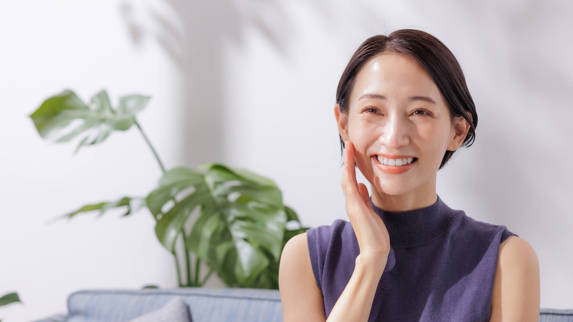 頬に手を当てほほ笑む女性