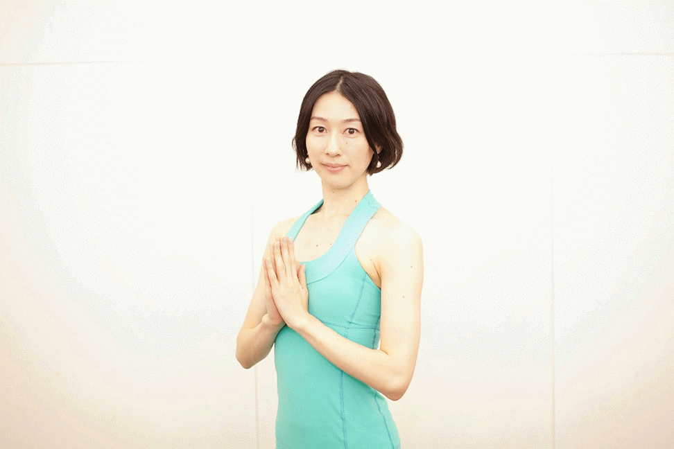 両手を合わせ微笑む女性