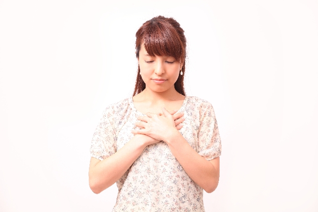 胸に手を当てる女性