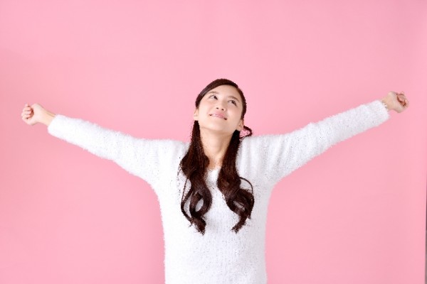 手を広げ胸を張る女性