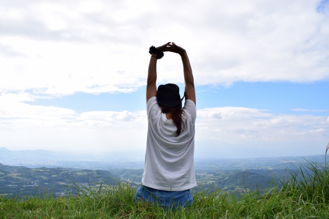 自然の中で伸びをする女性