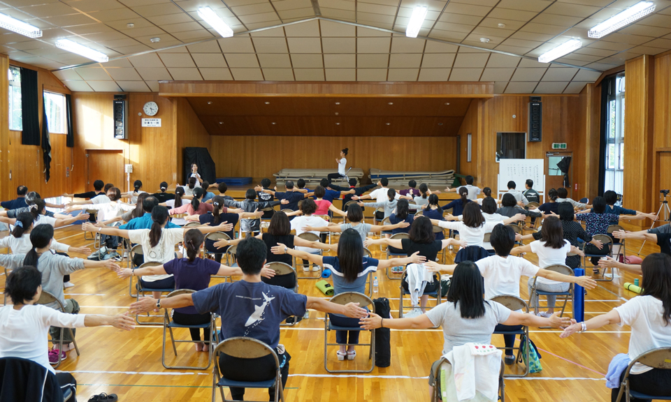 学校でピラティスをする教員と保護者