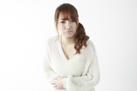 おなかを抱える女性