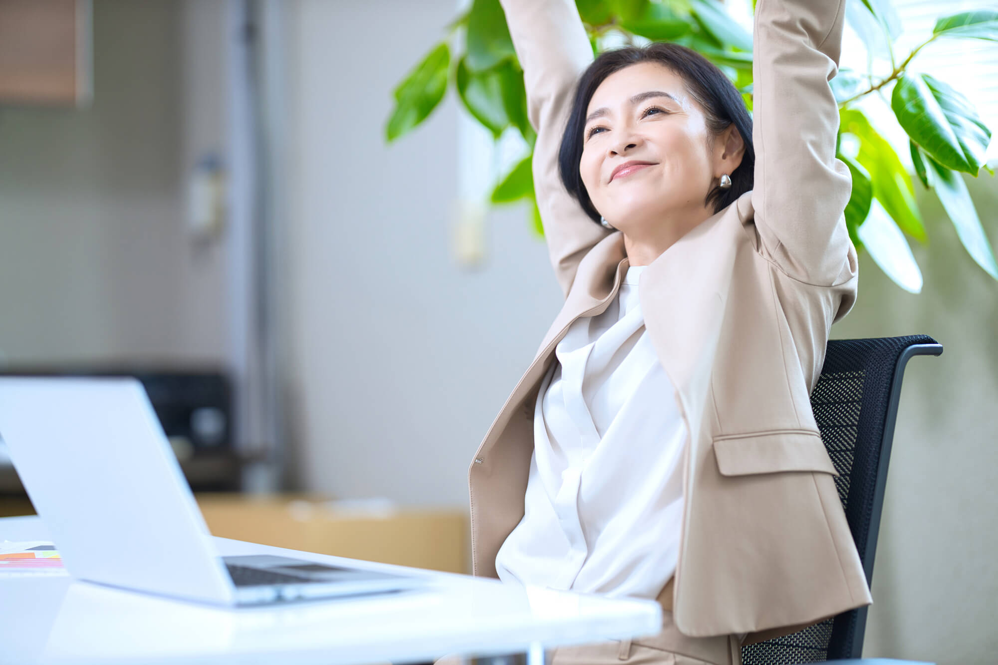 デスク前で伸びをする女性