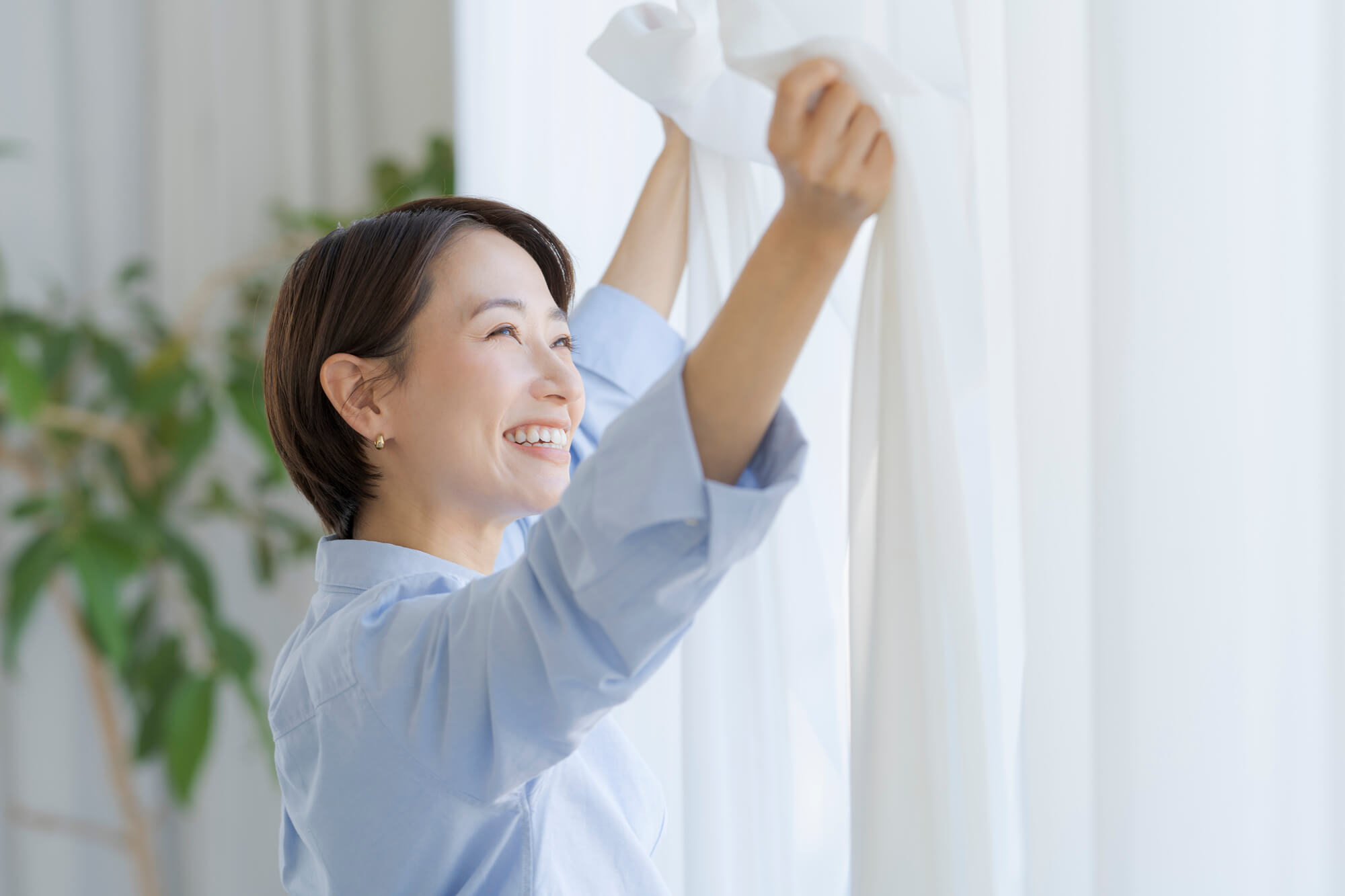 笑顔で窓際に立つ女性