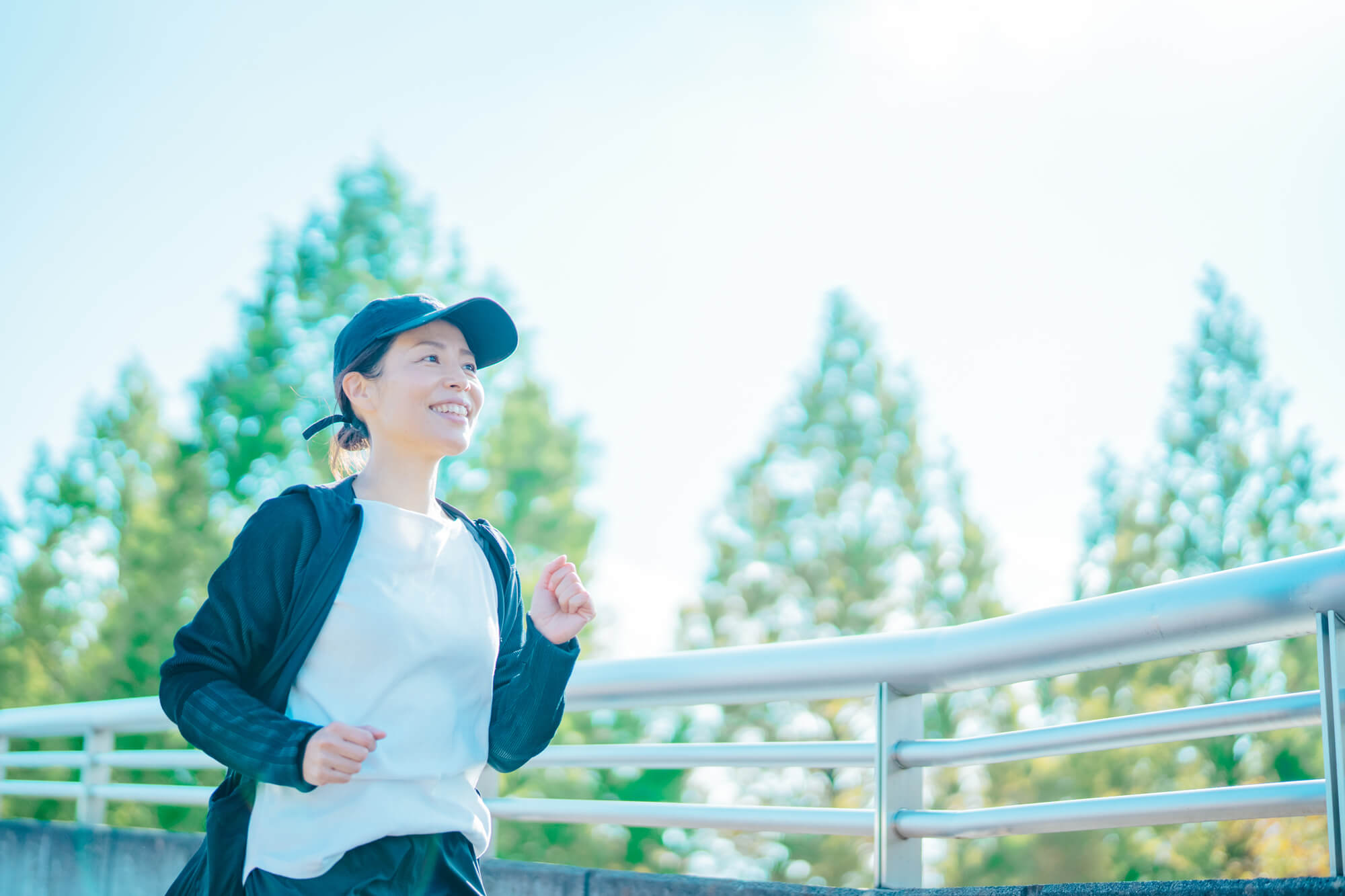 木々の見える場所でランニングする女性