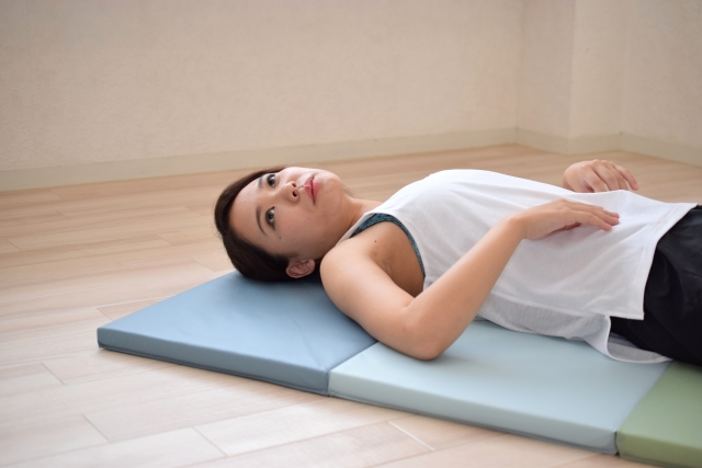 マットに横になる女性