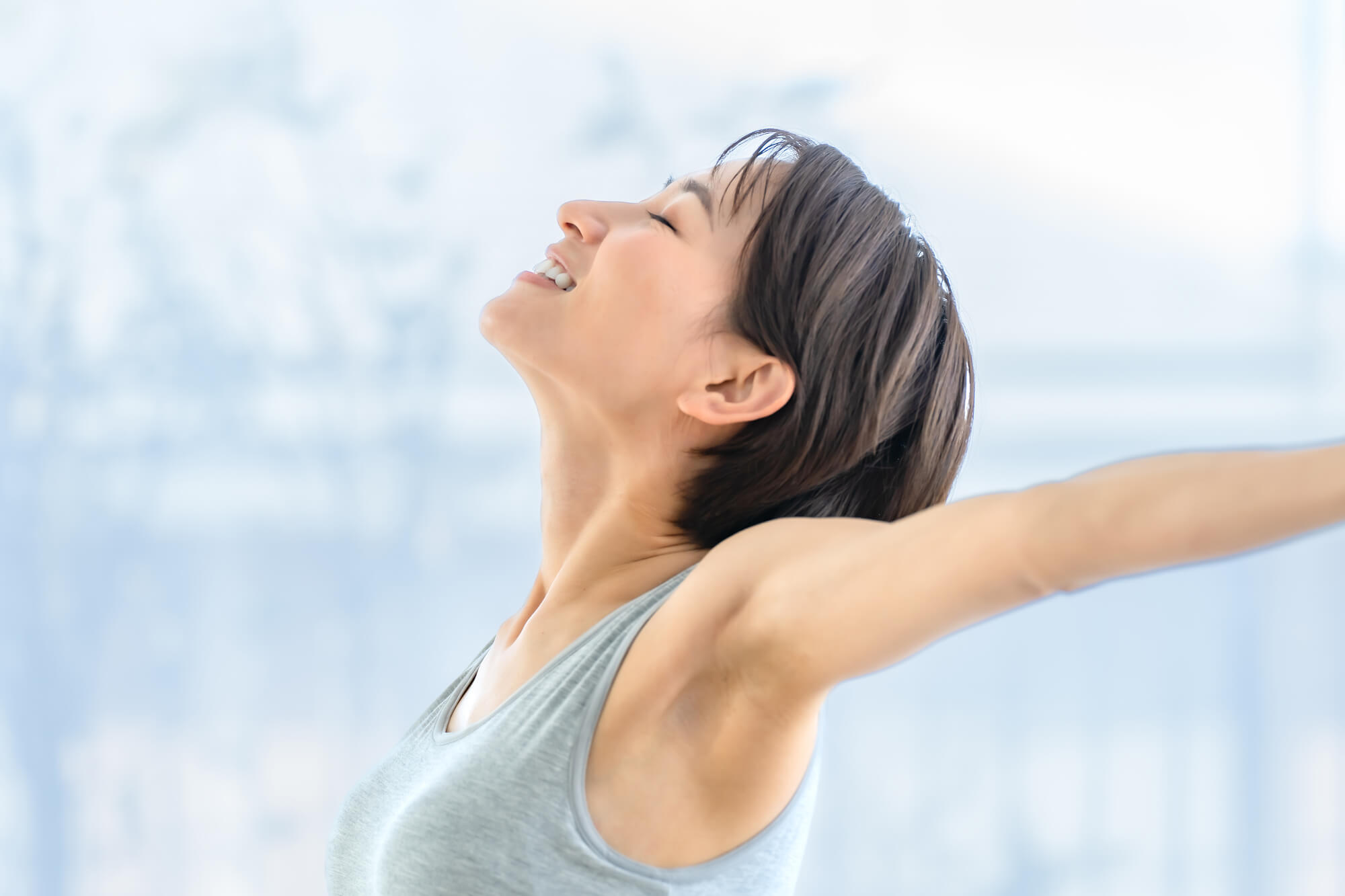 大きく伸びをする笑顔の女性