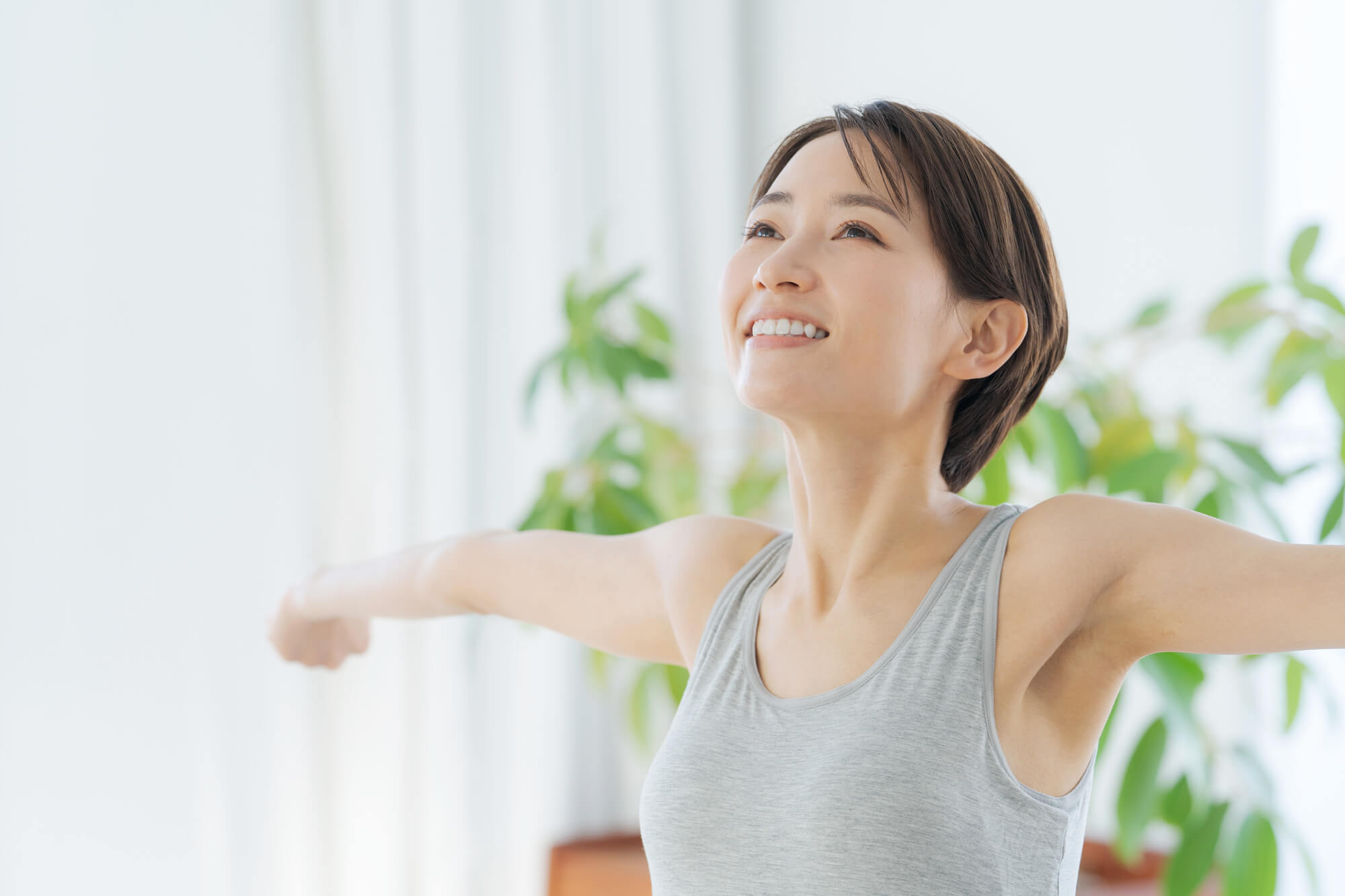 笑顔で伸びをする女性