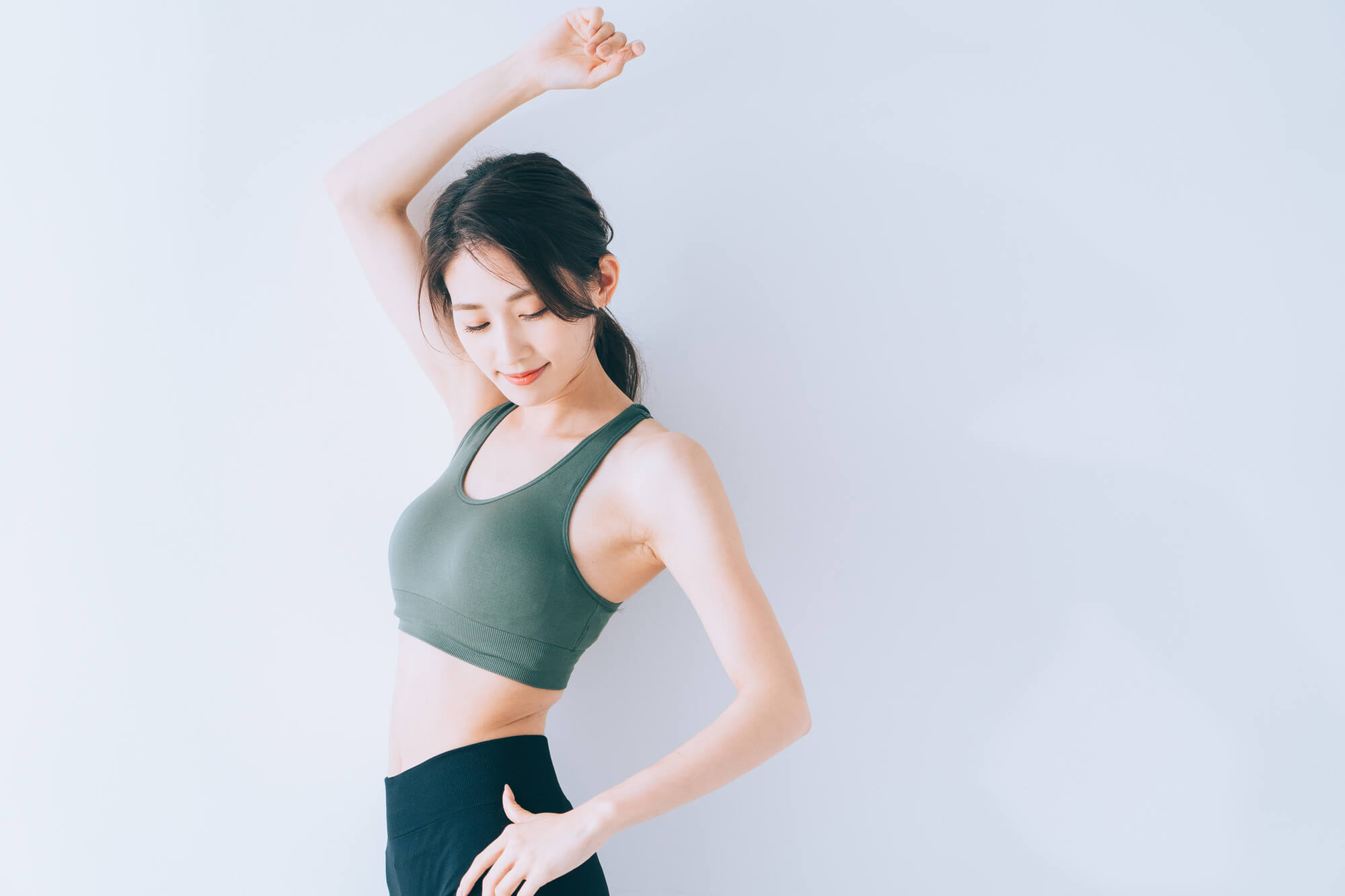 室内でウェアを着用してポーズを取る女性