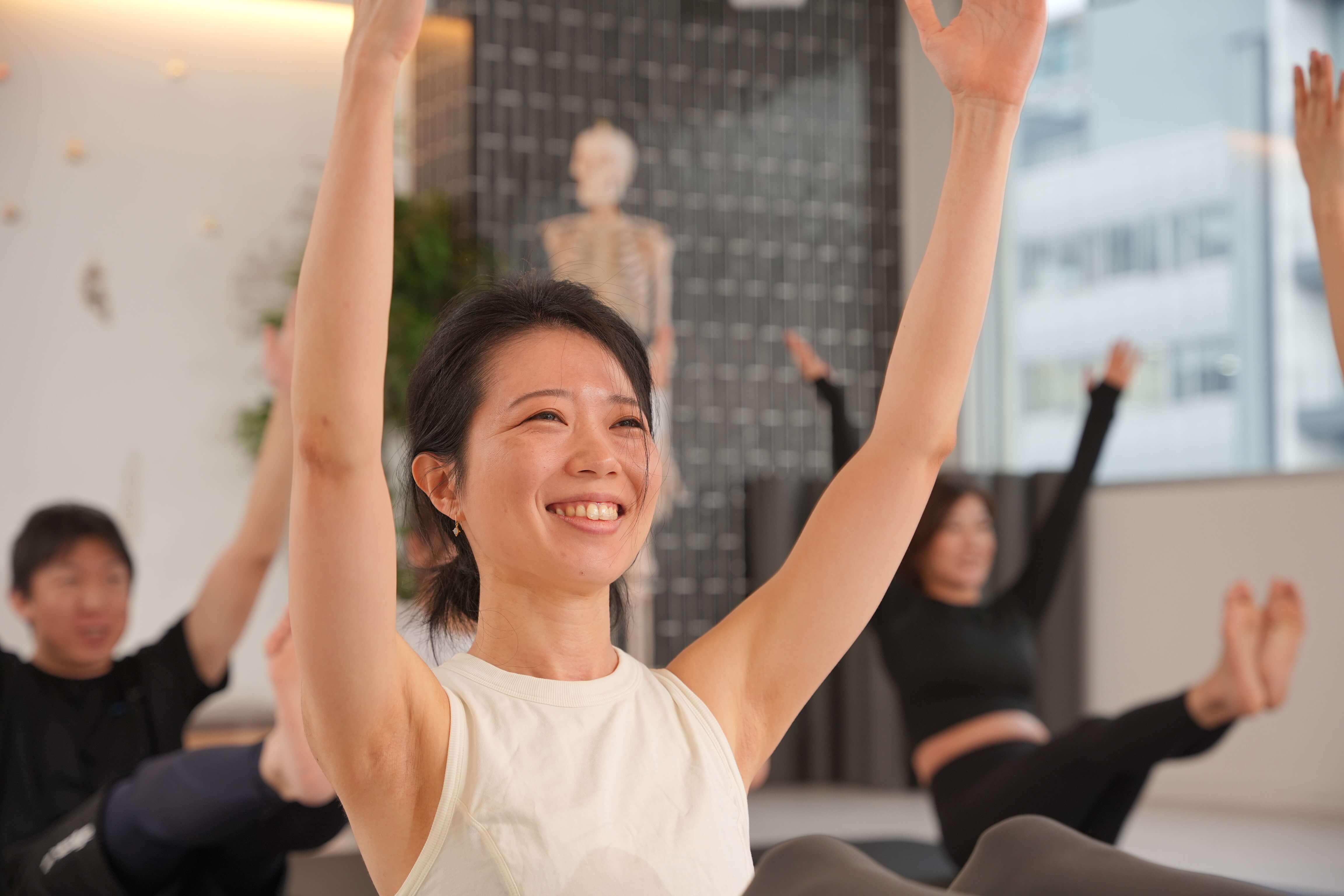 笑顔でピラティスのレッスンを受ける女性