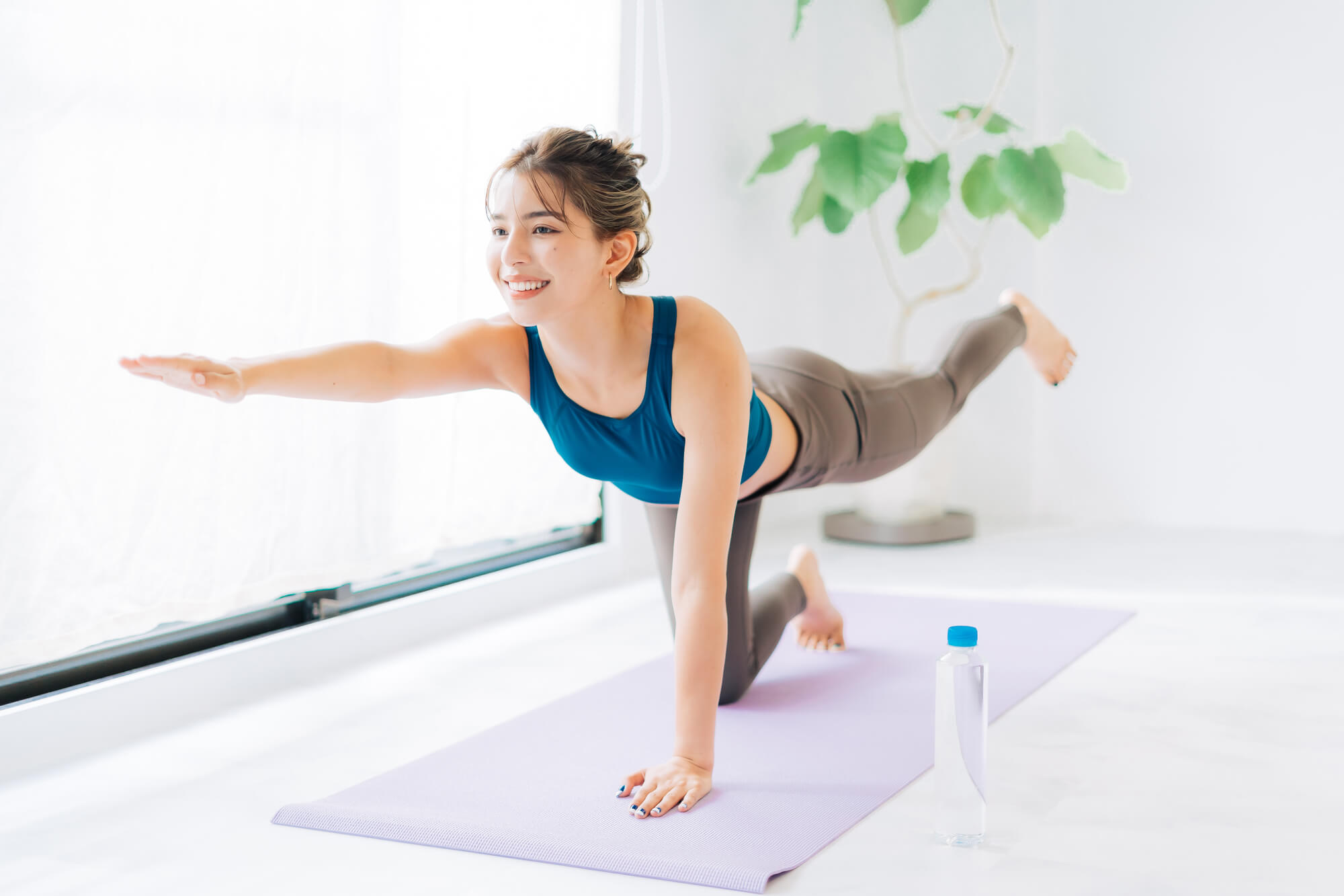 マットの上でピラティスに励む笑顔の女性