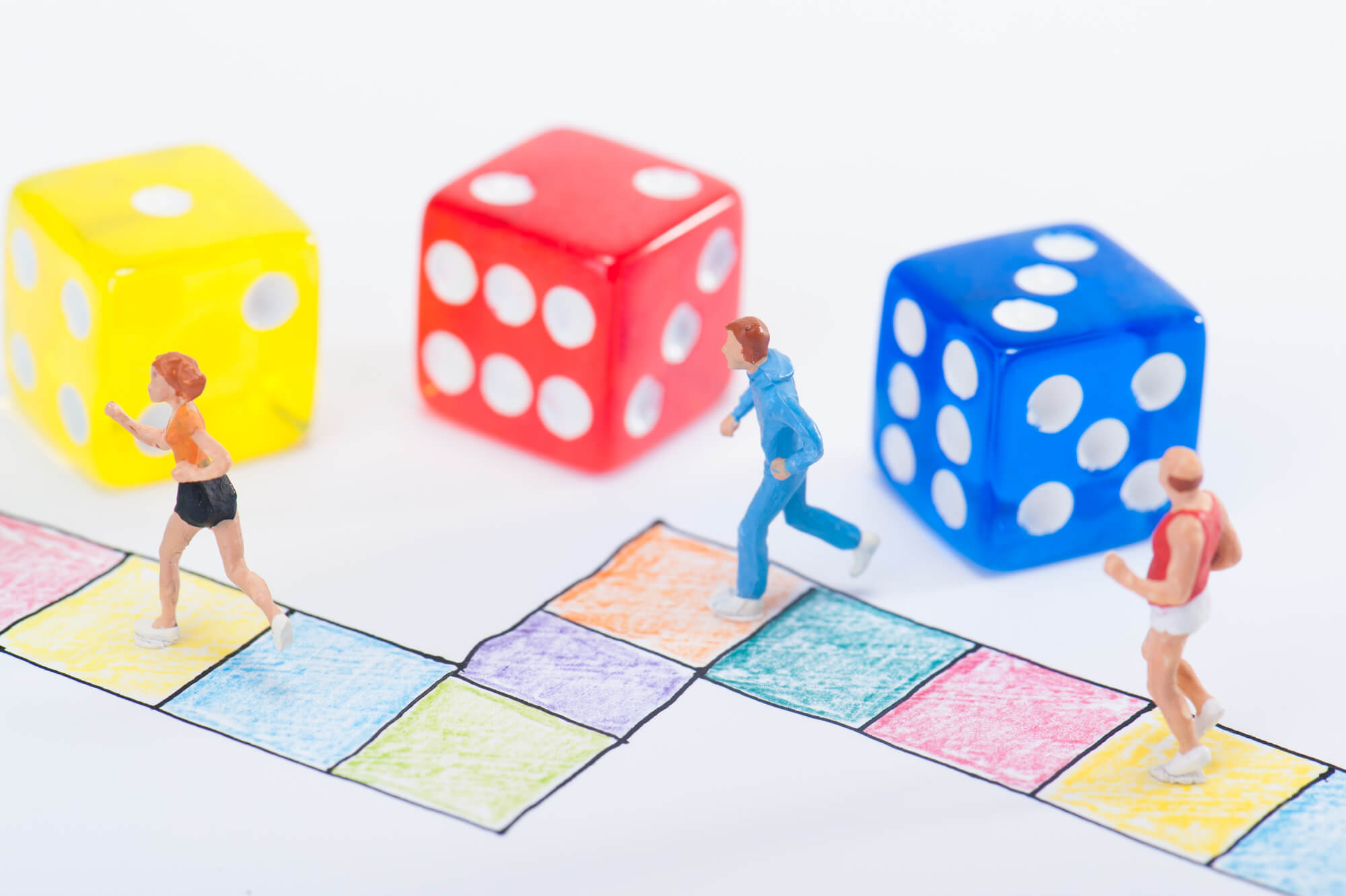 すごろくの上に置かれた運動をする人の模型とサイコロ