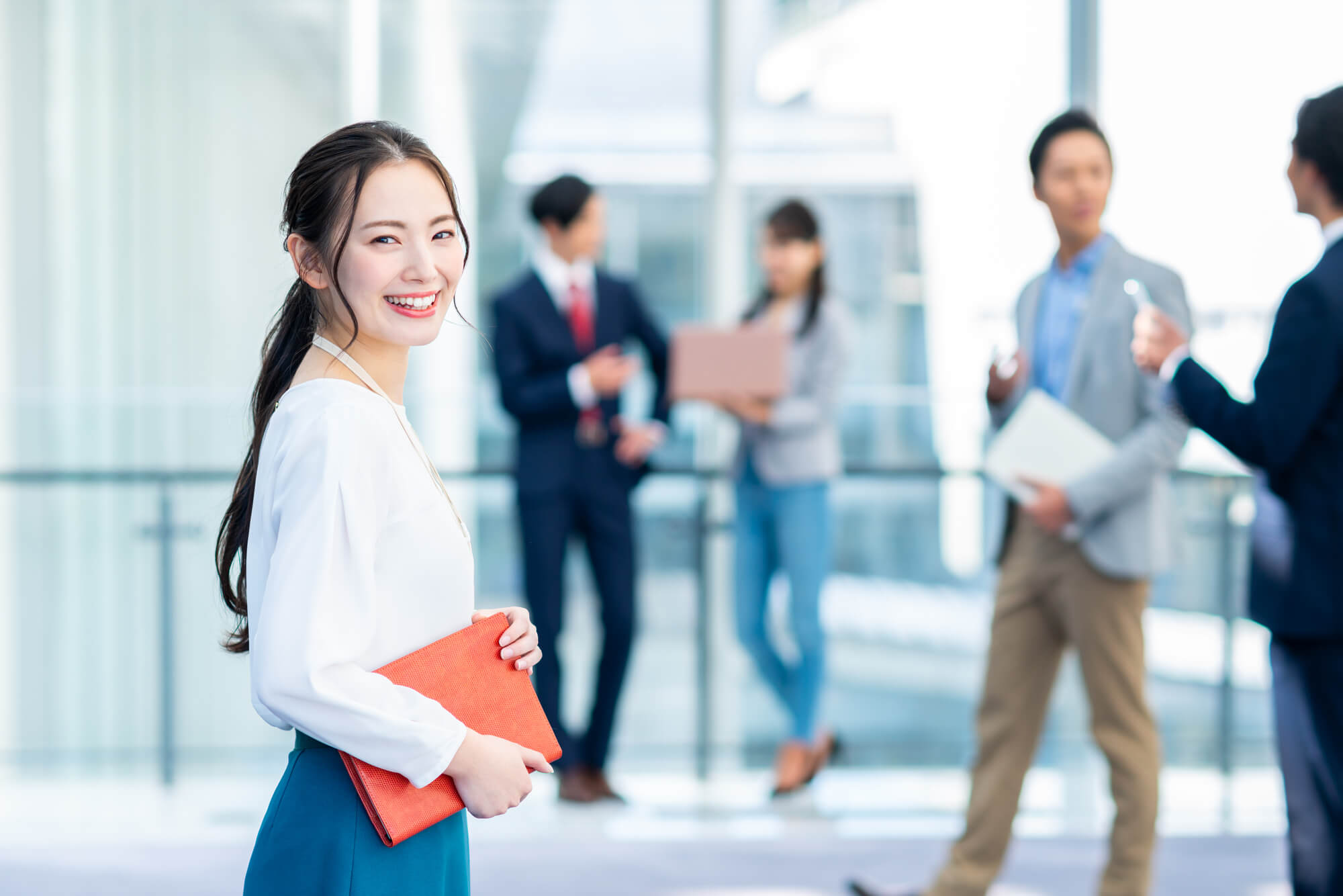 オフィスの廊下で笑顔を見せる女性