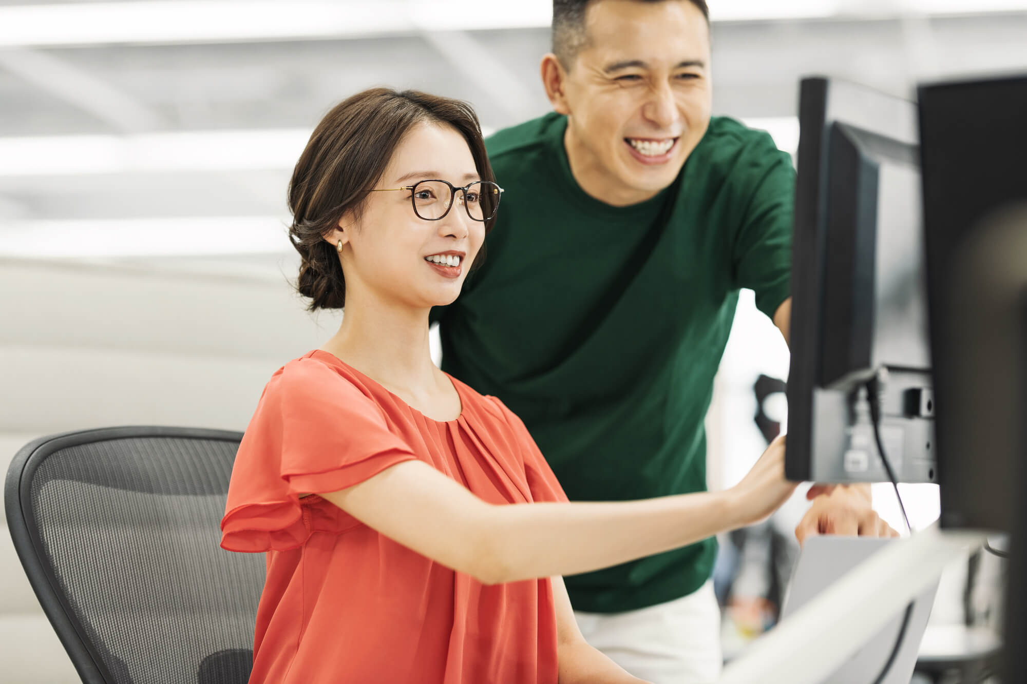 パソコンの前で指導を受ける女性