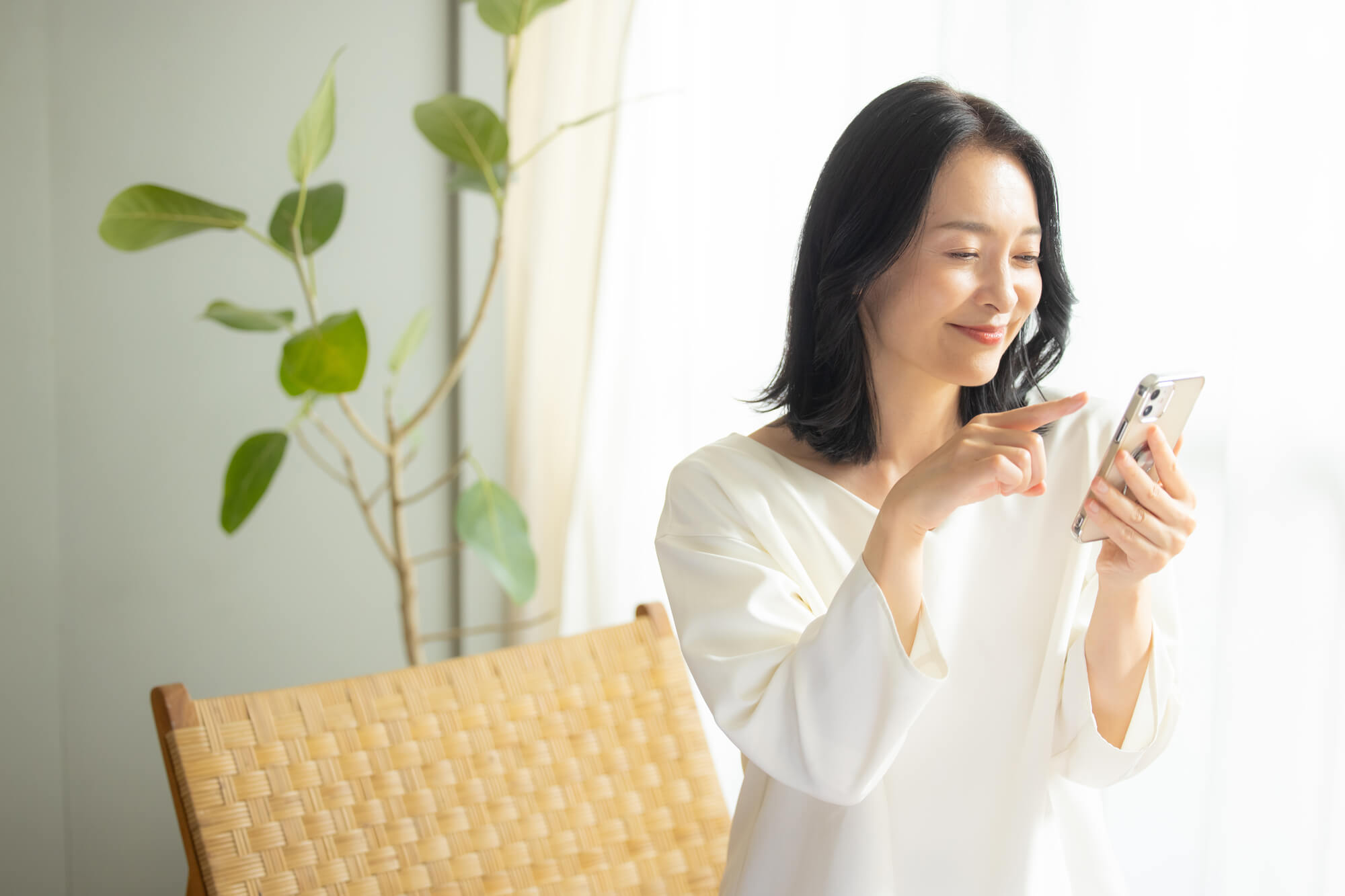 笑顔でスマホを操作する女性