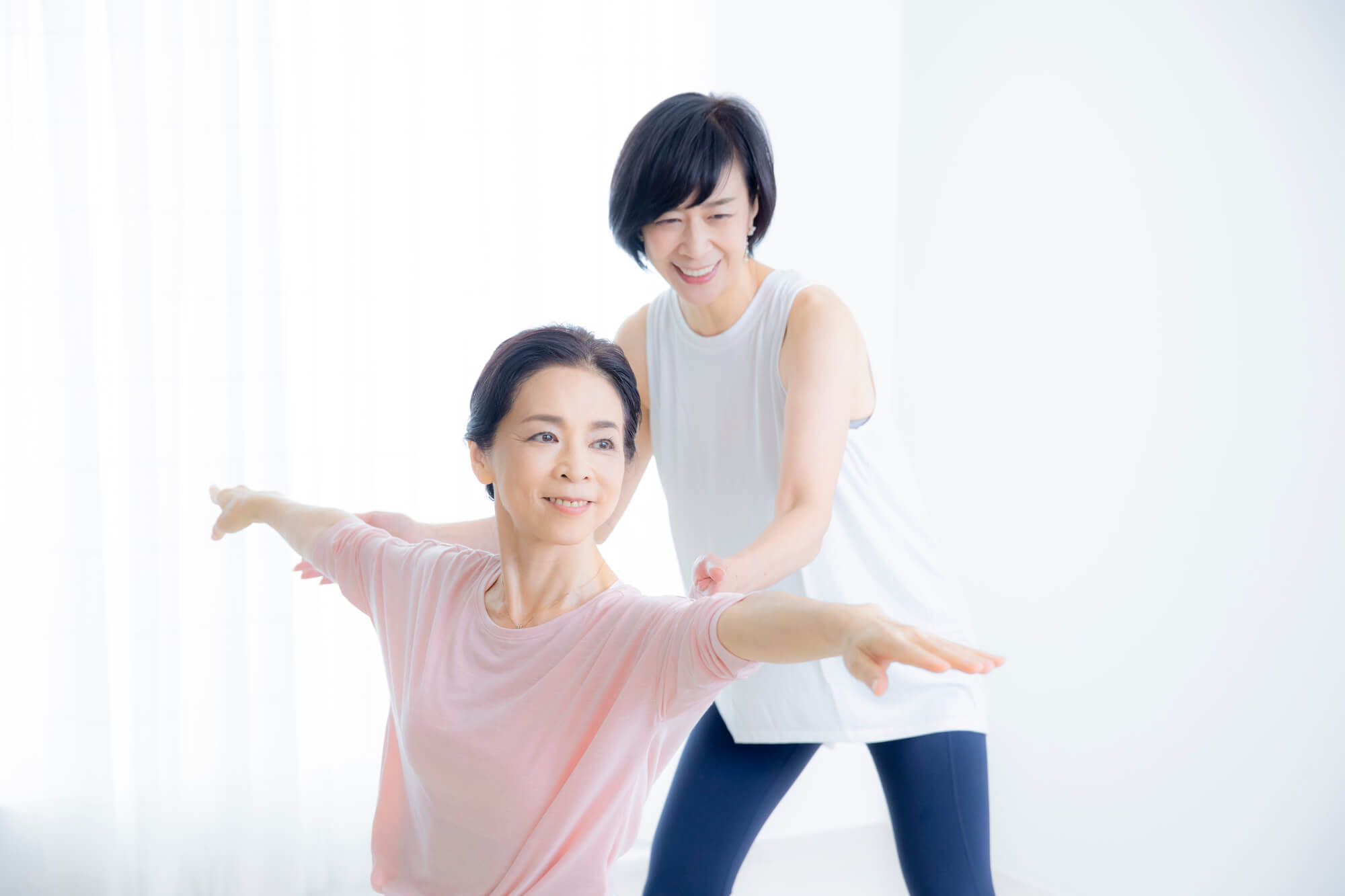 ピラティスのレッスンを受ける女性と指導者