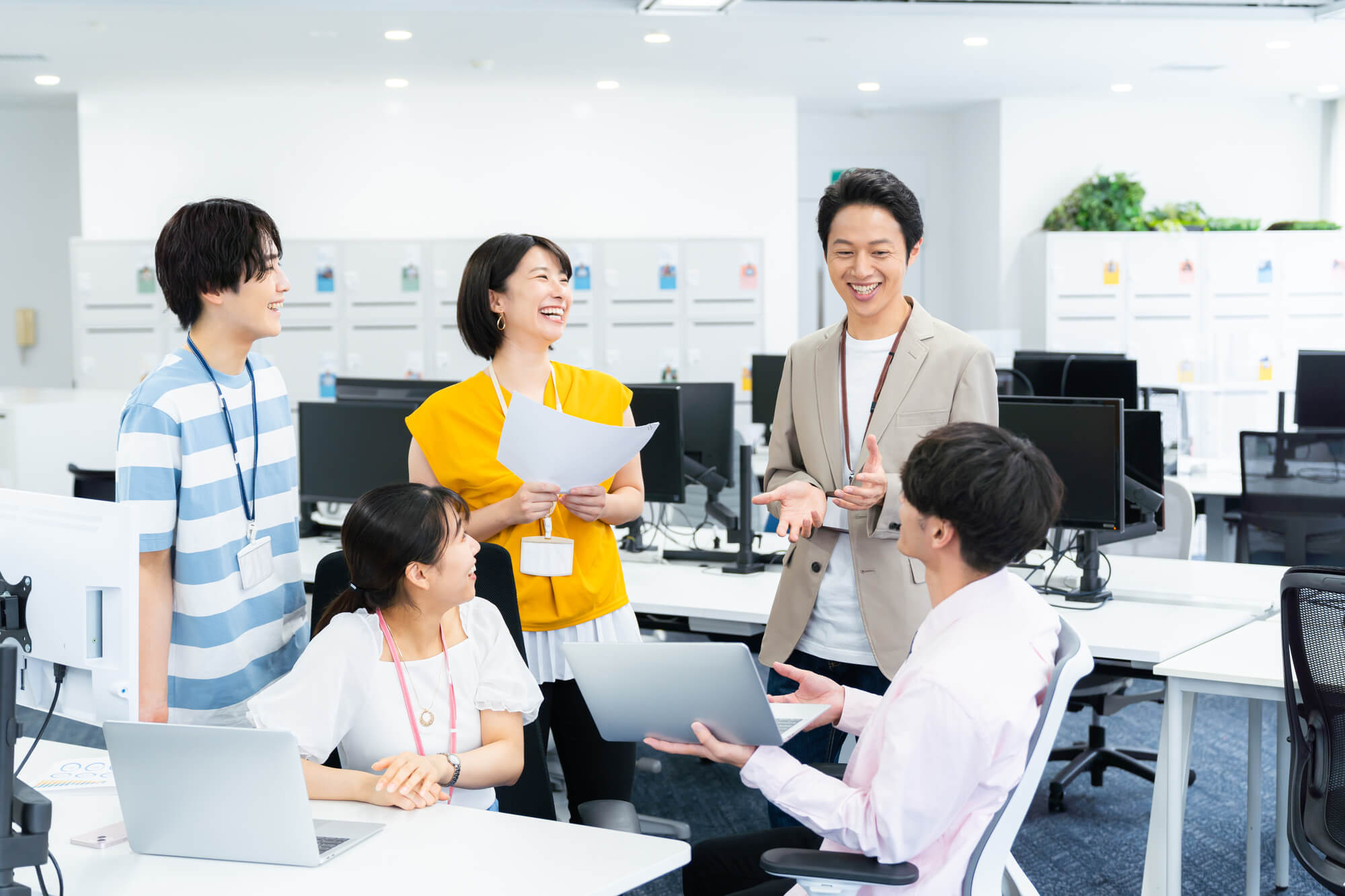 笑顔でミーティングをする5人の従業員