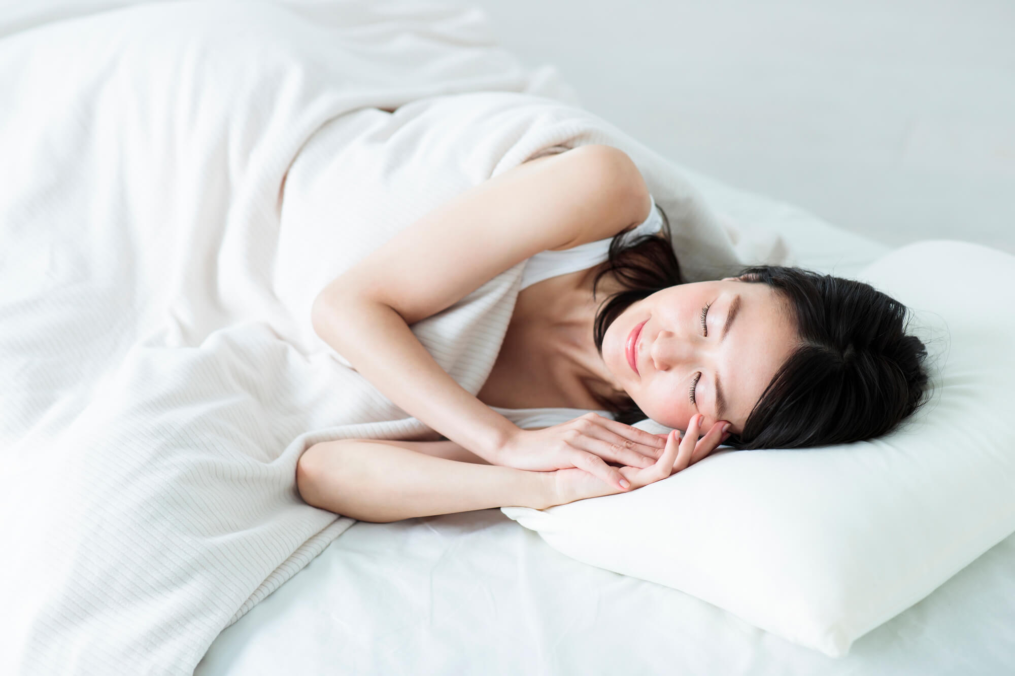 布団で健やかに眠る女性