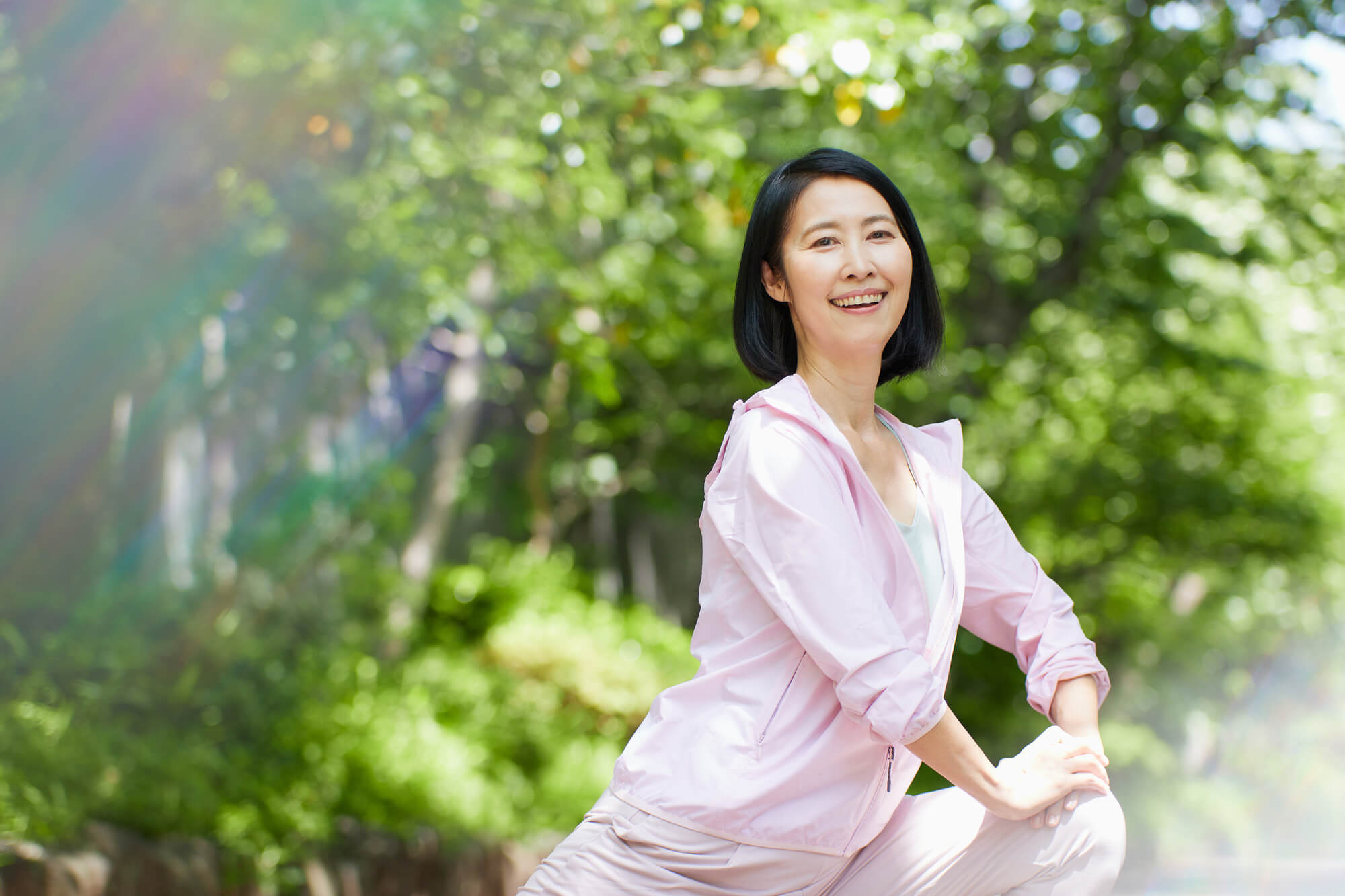 屋外でストレッチをする笑顔の女性