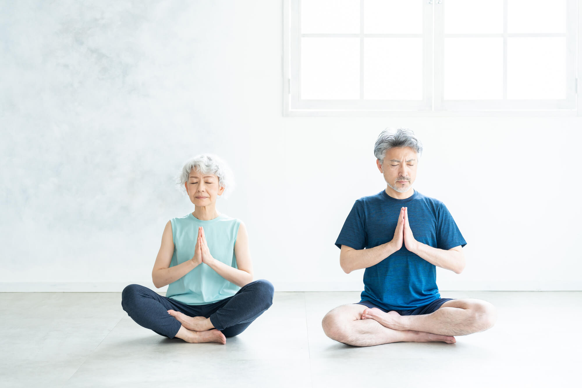 室内で瞑想をする夫婦
