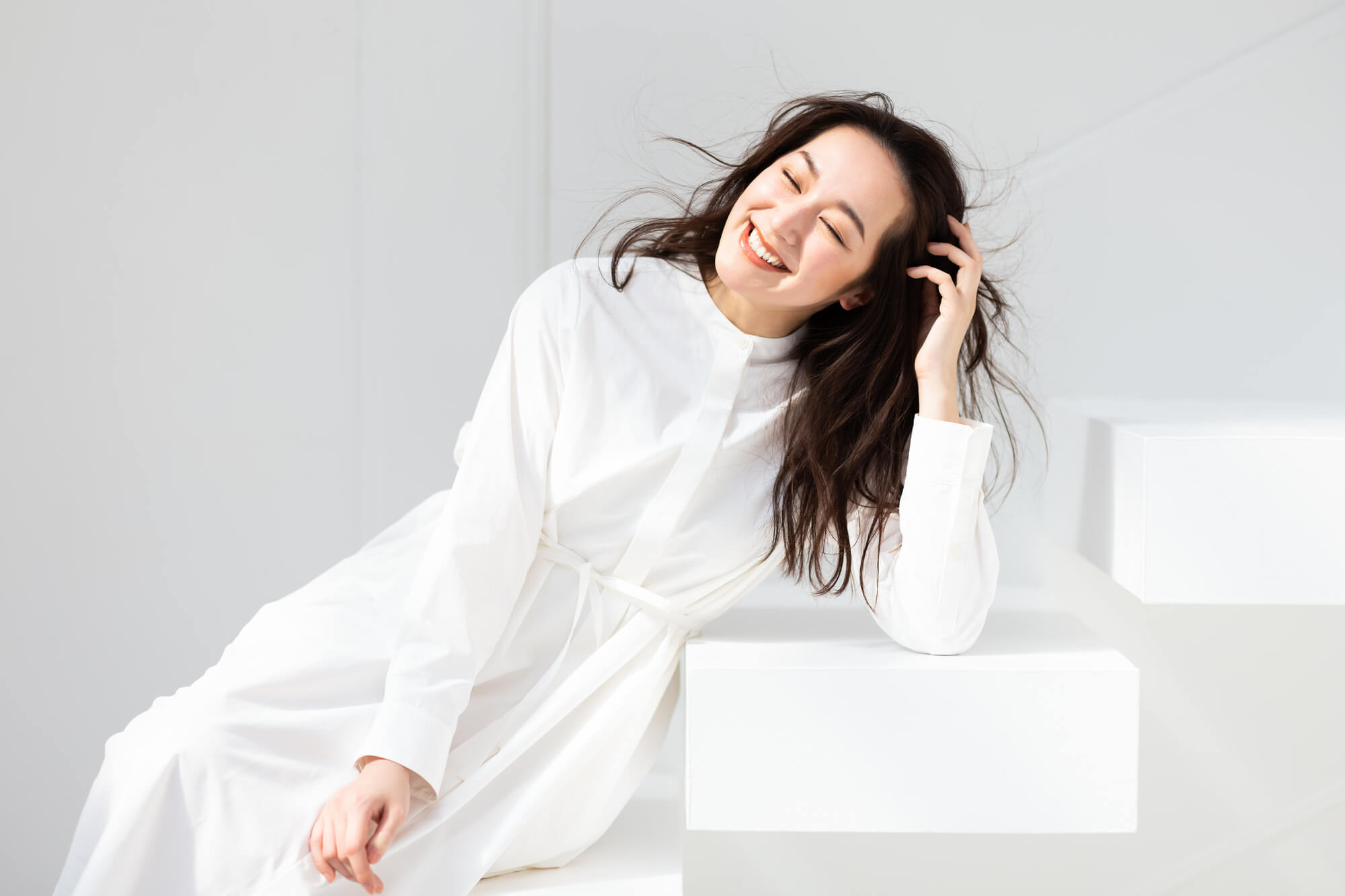 笑顔を浮かべる白い服の女性