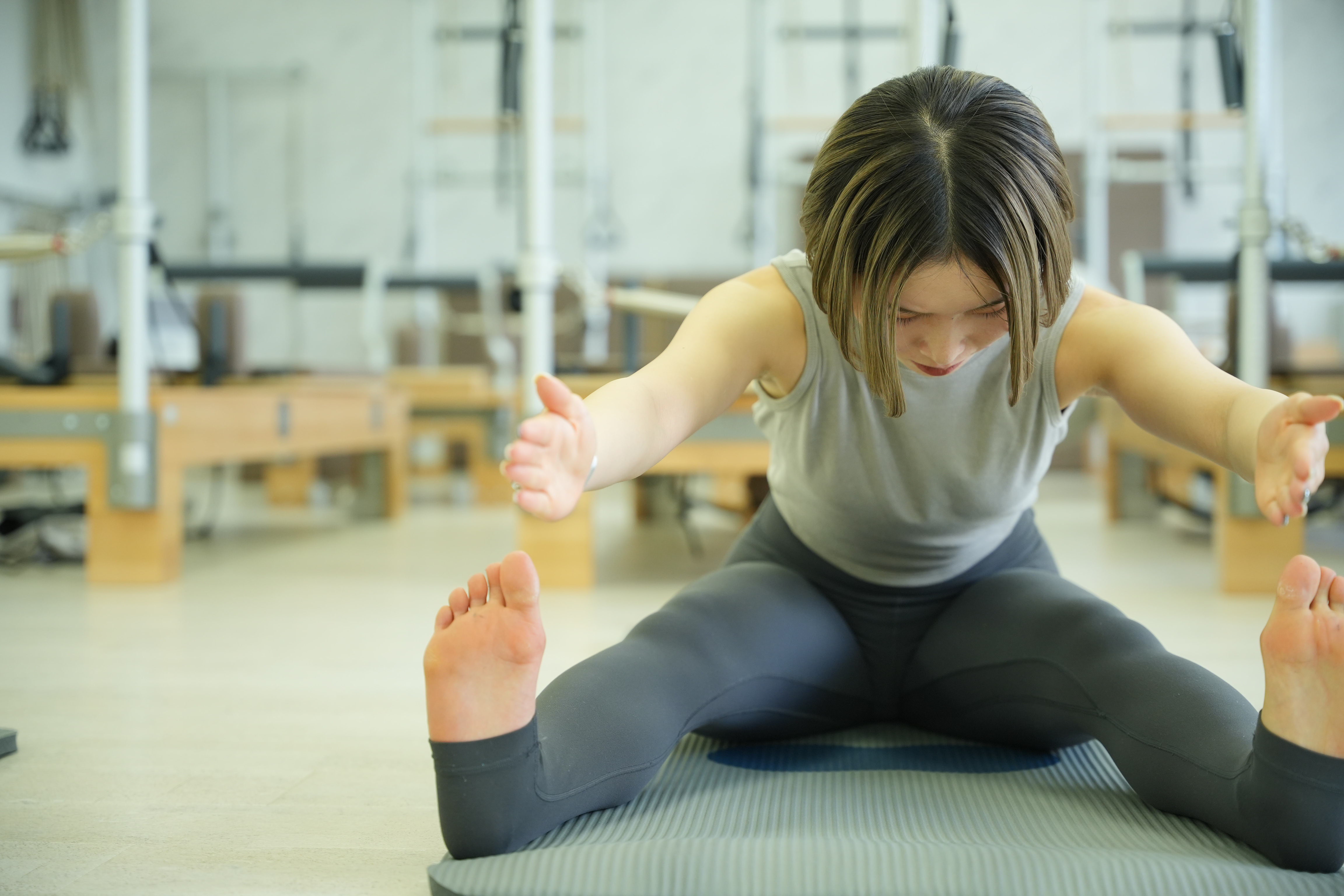 鏡の前で腰とおなかに手を当てる女性